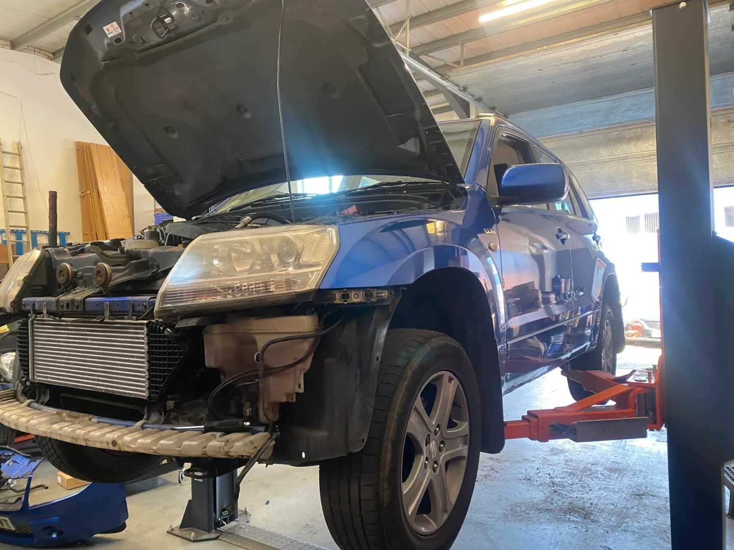 A Suzuki Grand Vitara up on the lift in the Attwood Motors workshop with its front bumper off to reach the intercooler